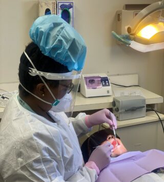 Tye cleaning Kecia's teeth.